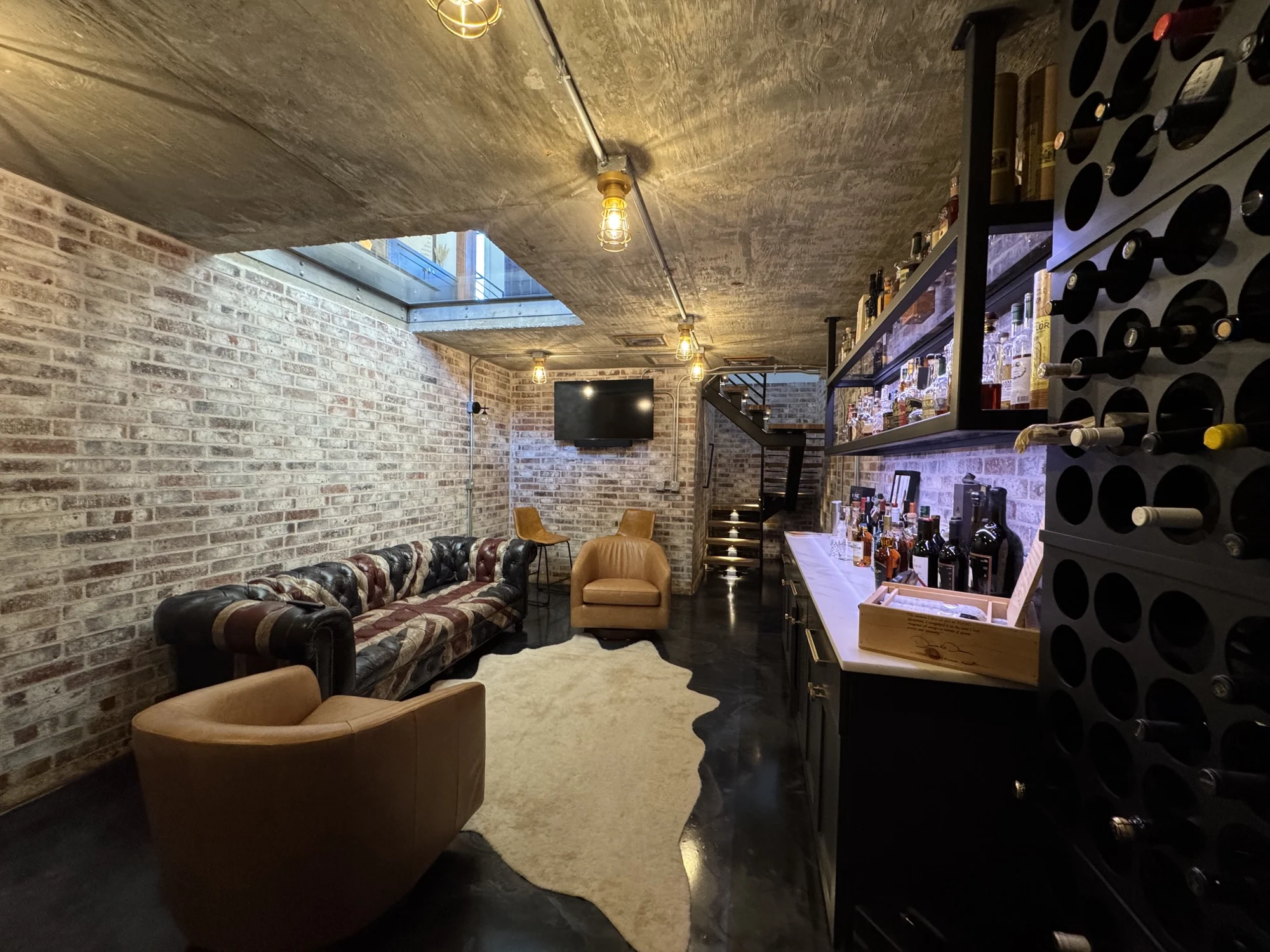 The cellar bar, bottle wall and brick lounge beneath the glass floor
